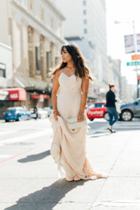 Stacey of StaceyAnnLoves wearing an ethically-made jewelry by Soko and using a vintage clutch and wearing ethically-made gown by Celia Grace Dresses while outside in downtown San Francisco