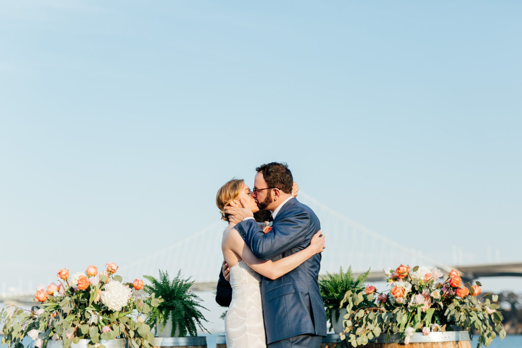 Bride and Groom on Treasure Island with the Bay Bridge first kiss in the background