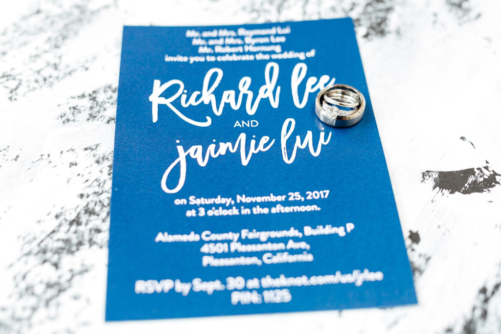 bride and groom invitation with rings on top