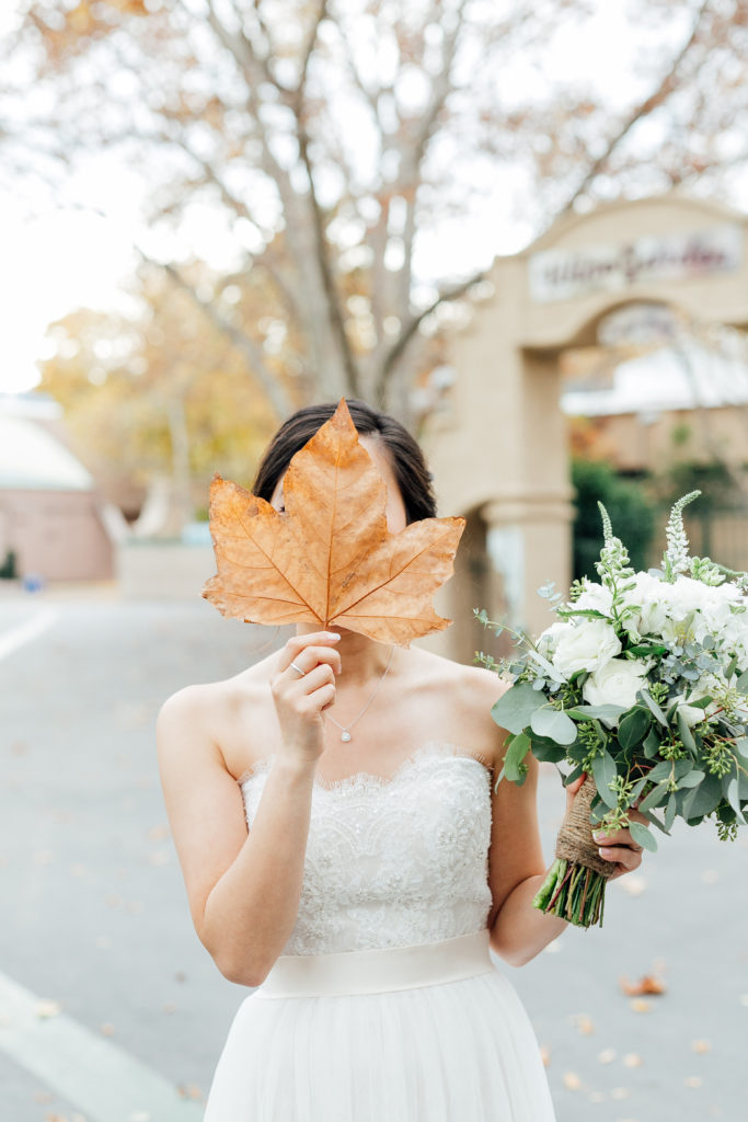 Bride holds large leaf over face