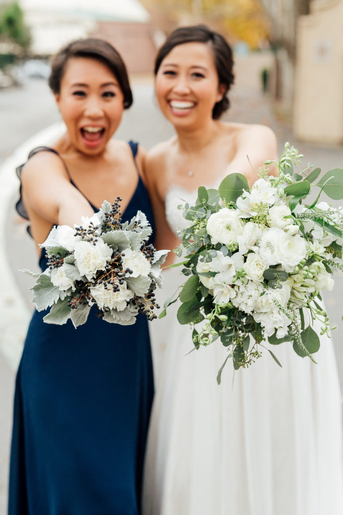 bride and bridesmaid hold out bouquet