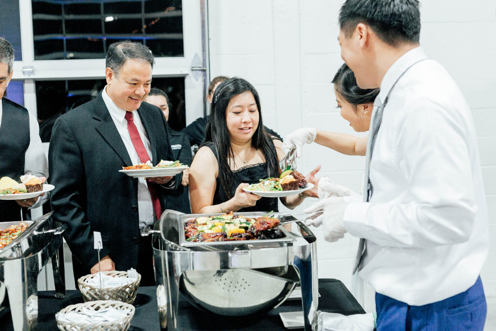 Bride and groom serve dinner food to their guests because service was one of their main values