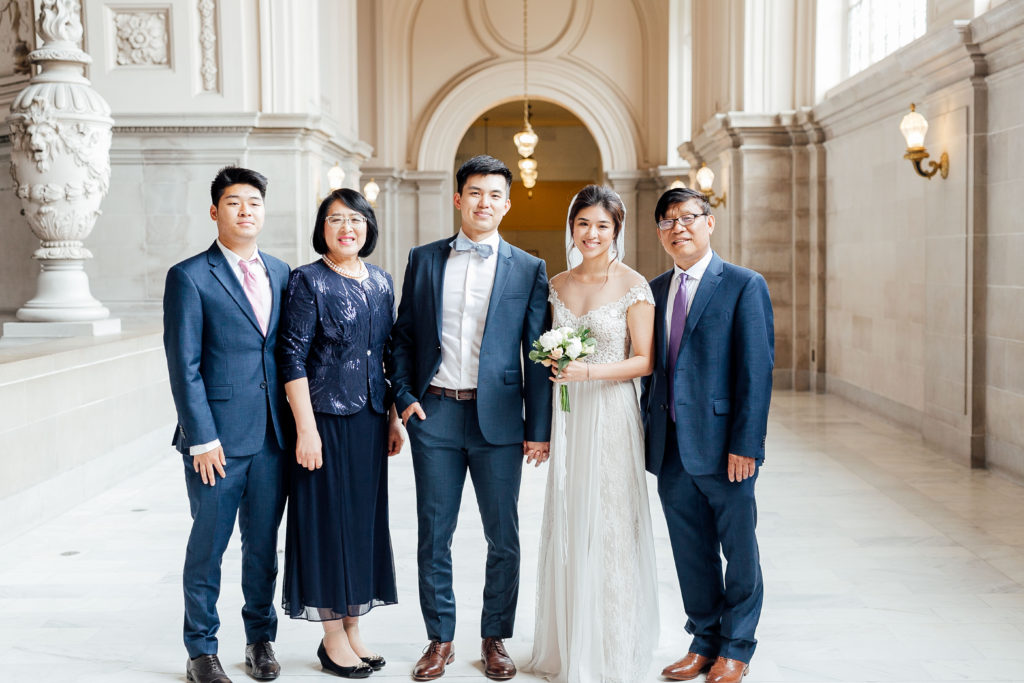 Bride and groom pose with family members in city hall