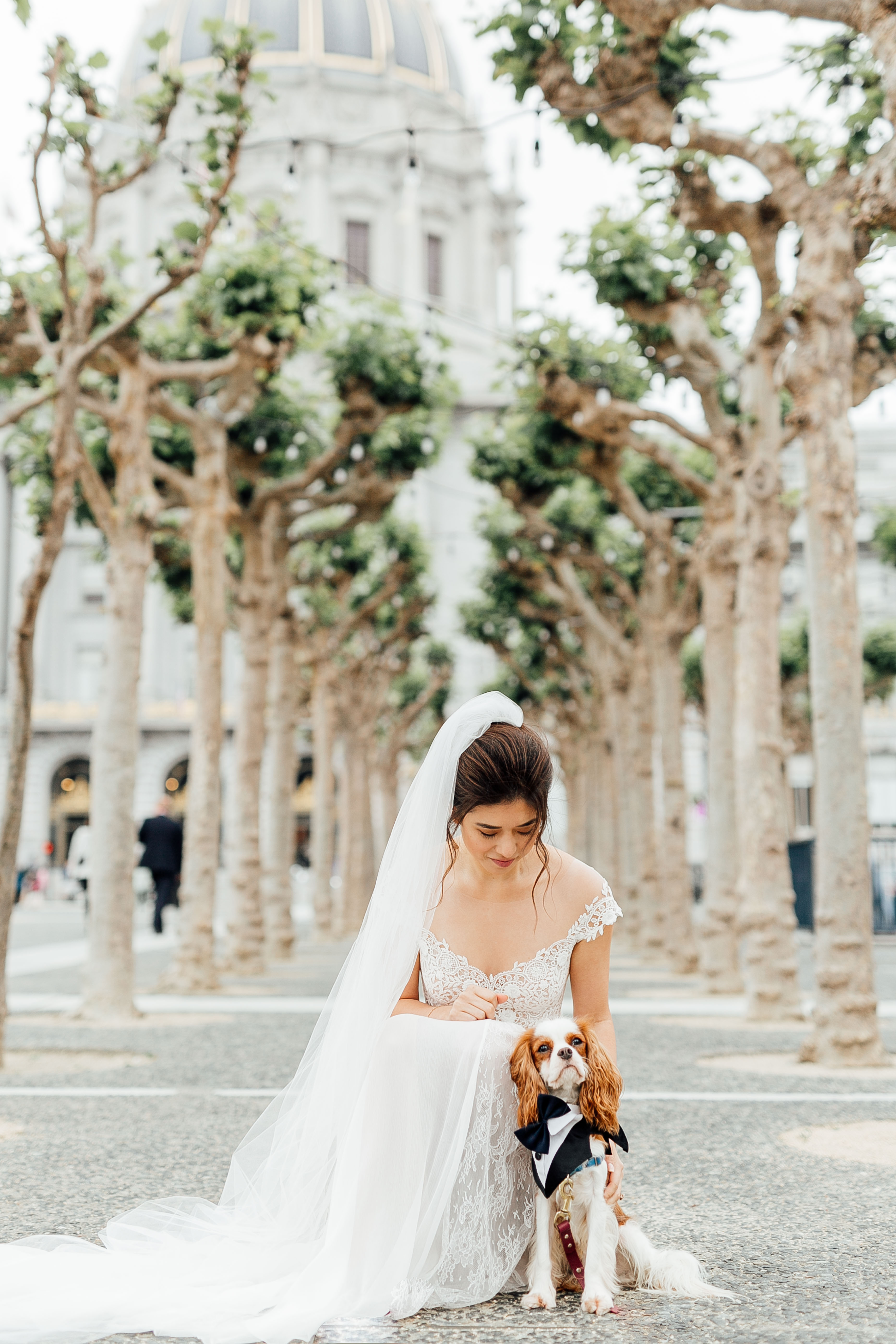 Bride poses with dog outside of the main City Hall