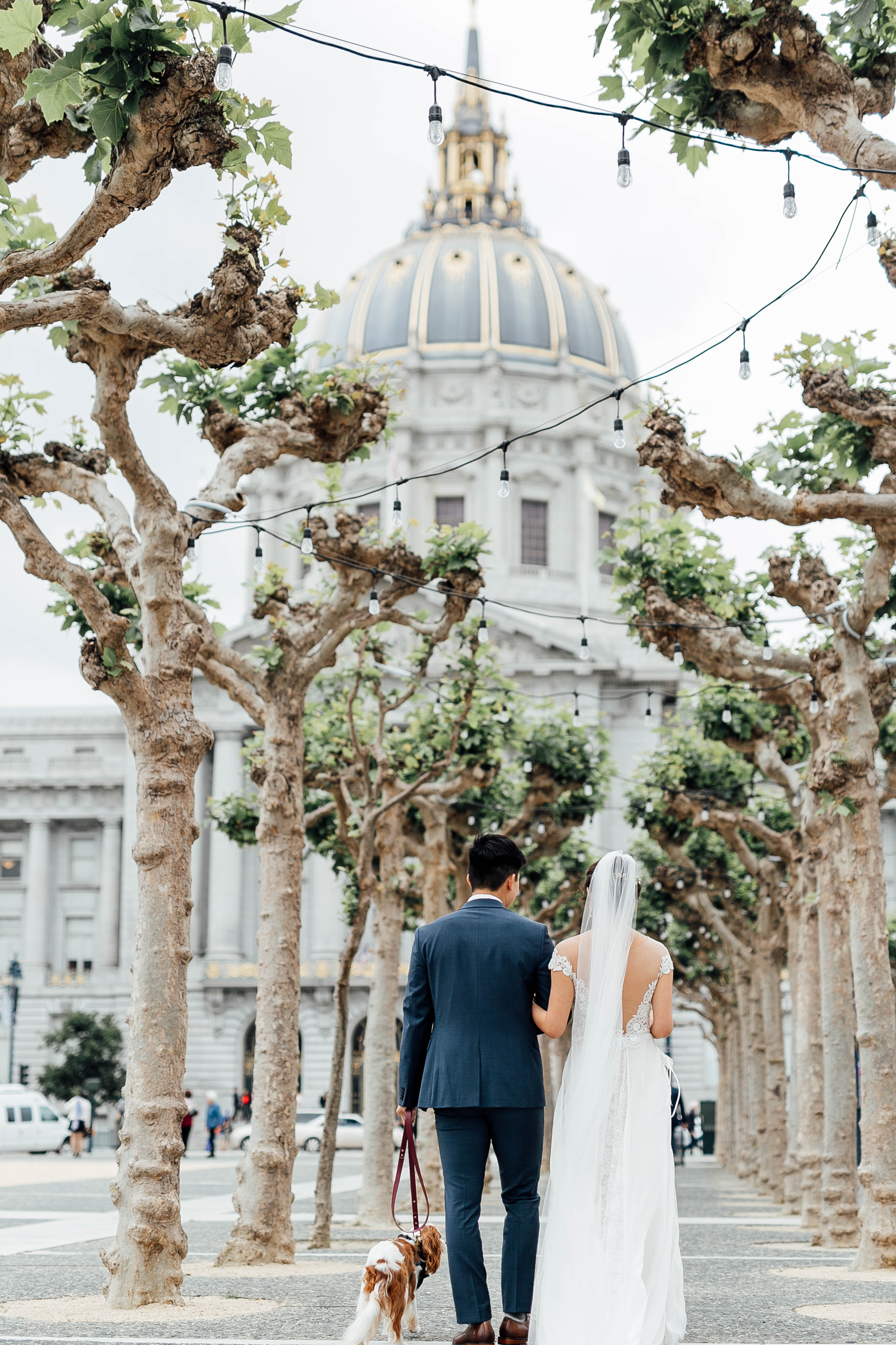 Bride and groom hold each other as they stand outside of City Hall