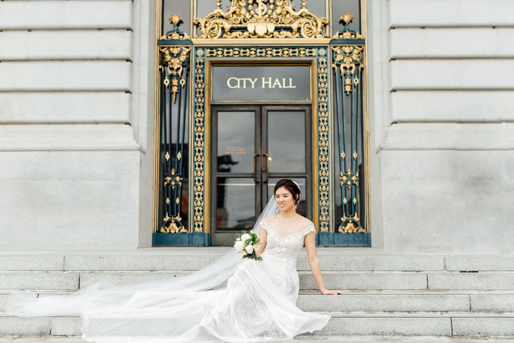 Bride sits on steps in front of main City Hall doors