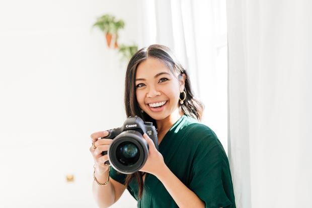 Female Photographer holding camera and smiling