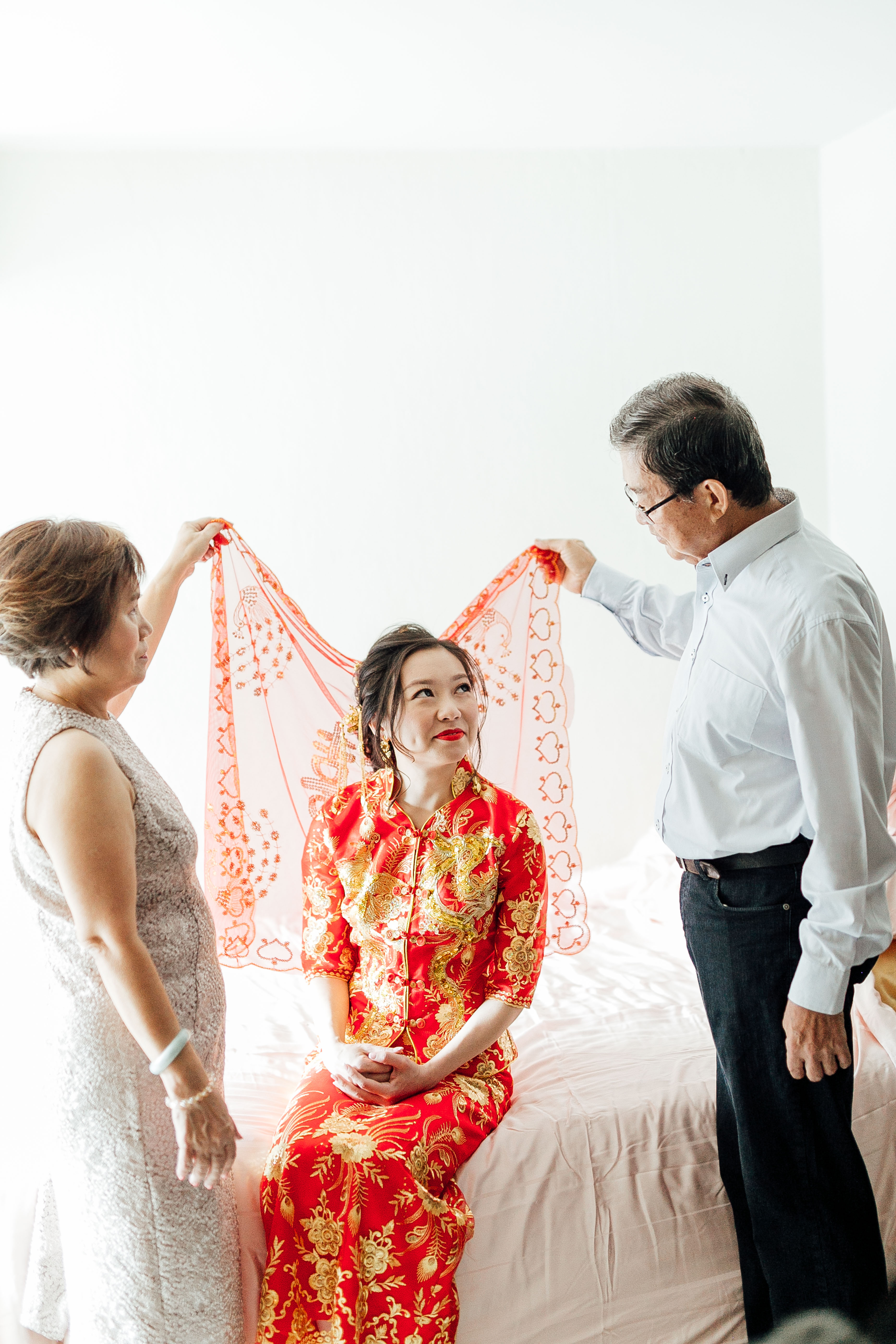 Bride with her parents and under a traditional cloth