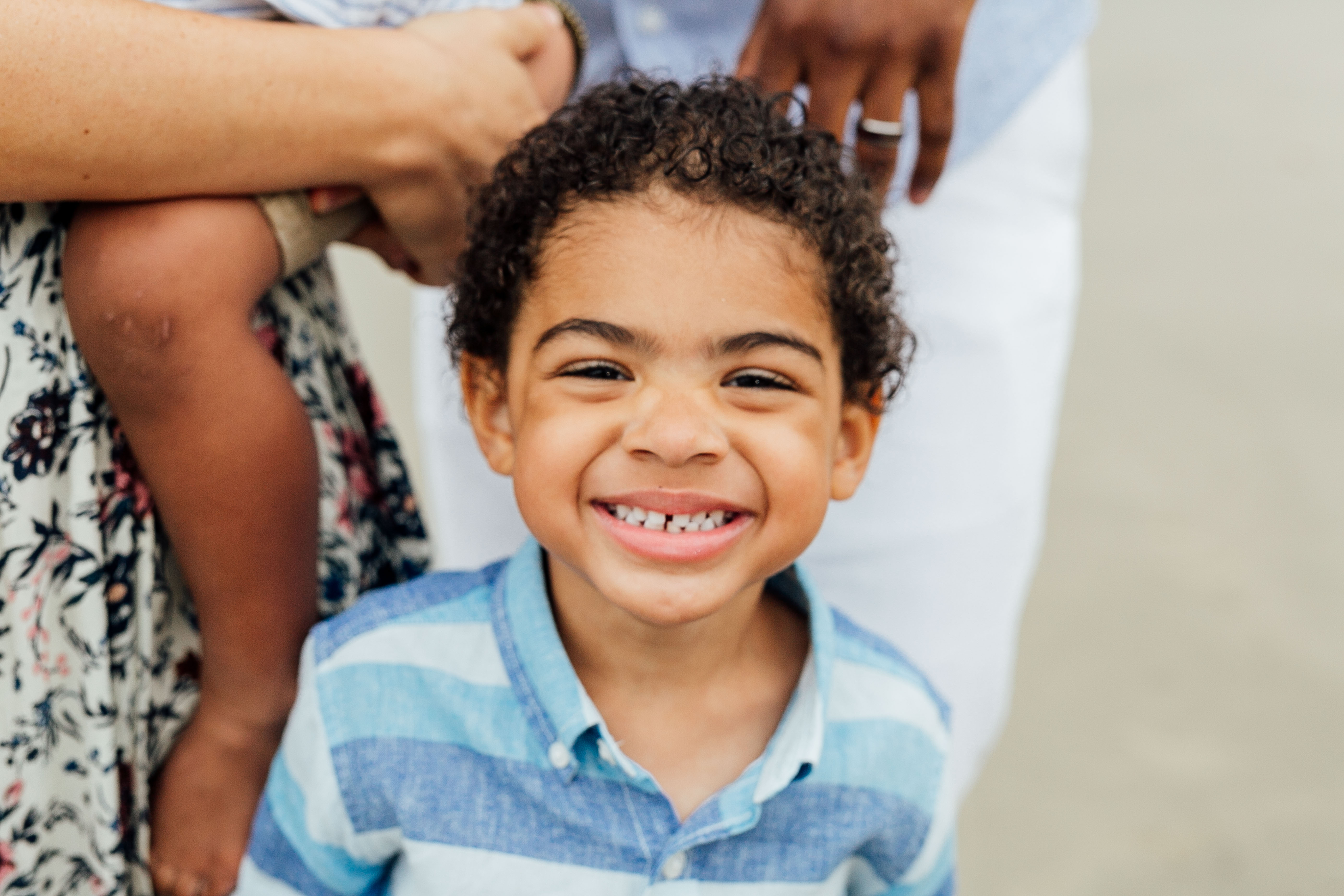 Boy smiling at family portrait session by ComePlum