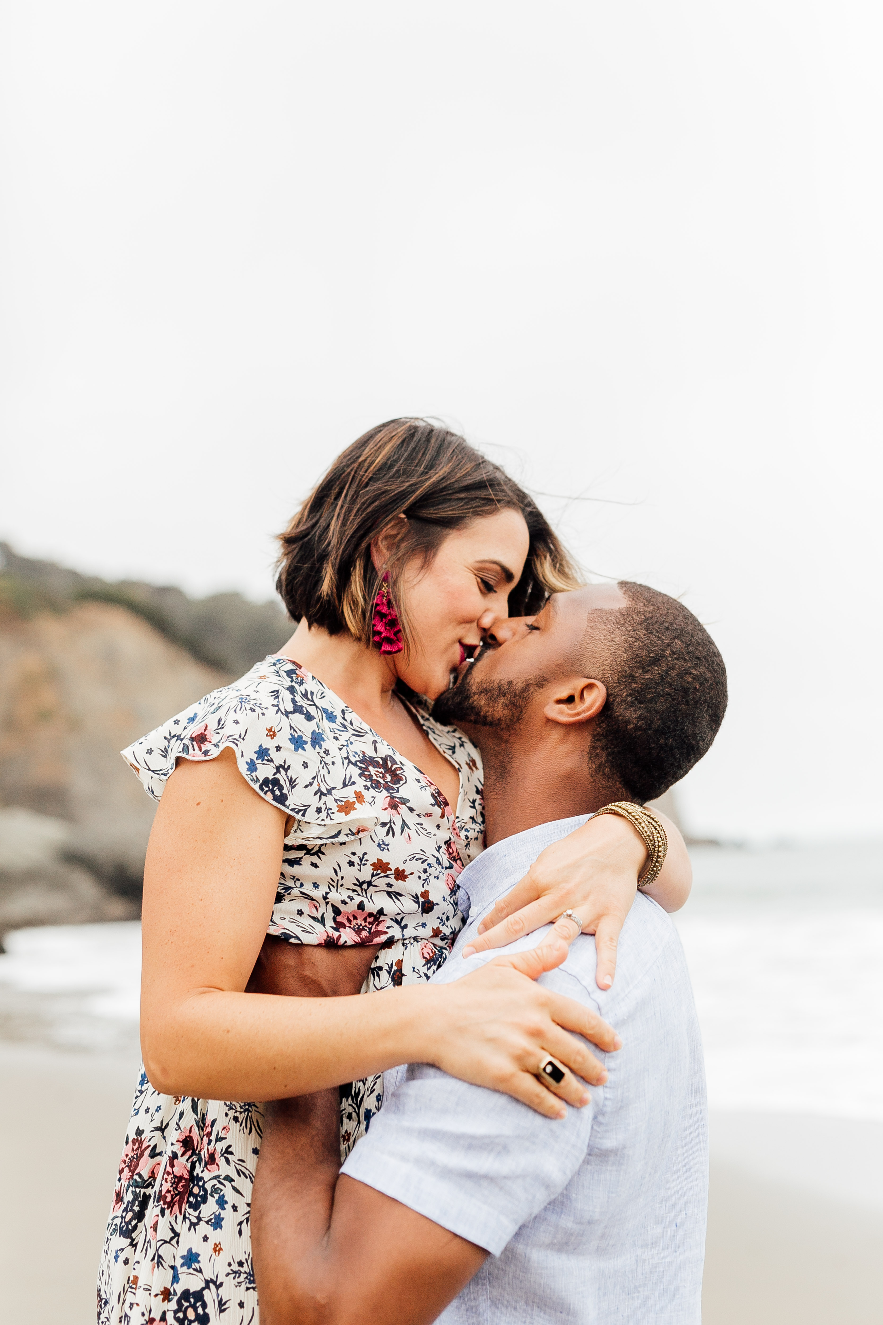 a couple kissing at China Beach during a family photo shoot with ComePlum 