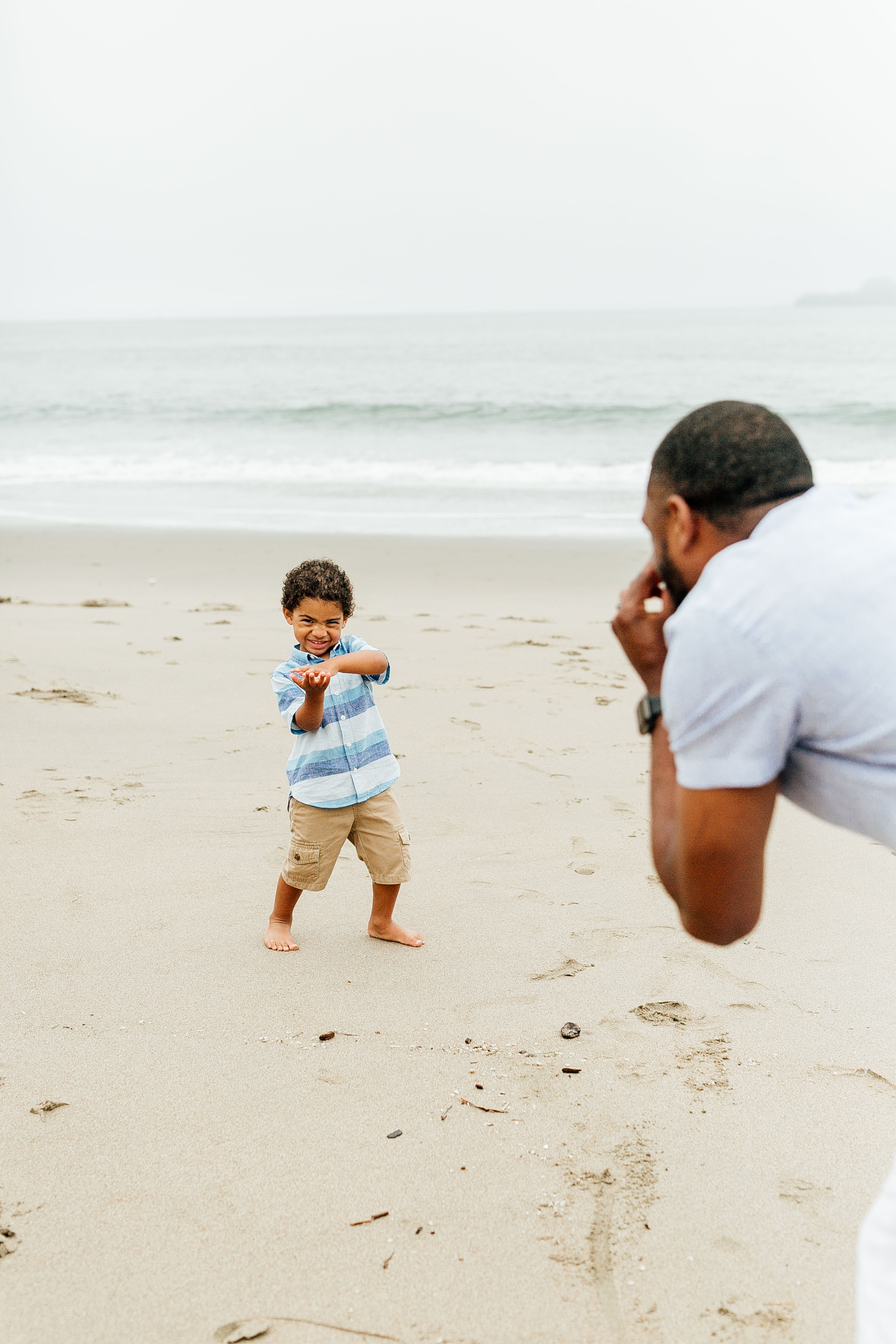 Boy playing take my picture with Dad at China Beach photo session by ComePlum