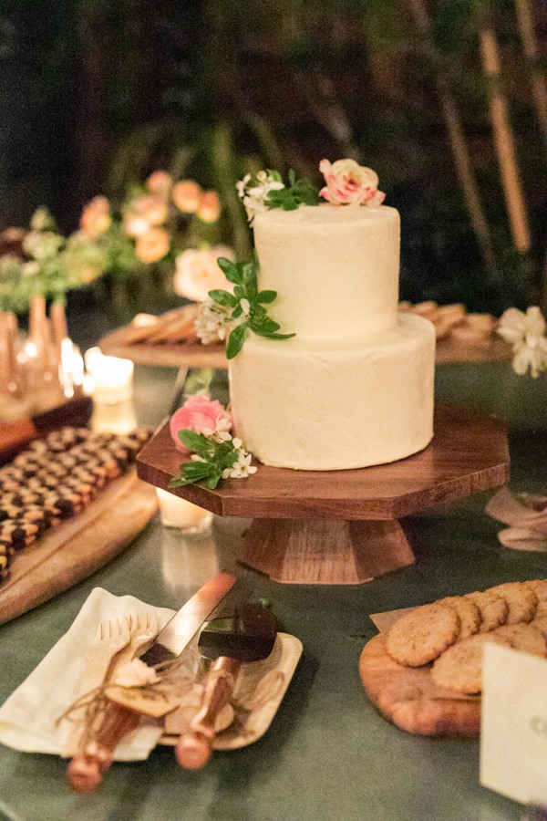 The minimal wedding cake is topped with local flowers.