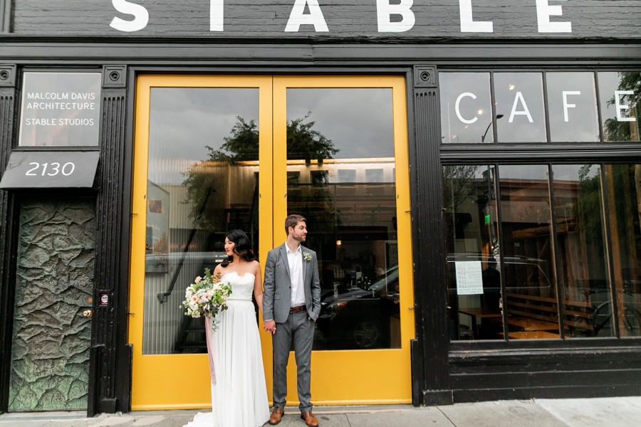 The bride and groom pose in front of the stable cafe, a wedding reception venue in San Francisco, CA.