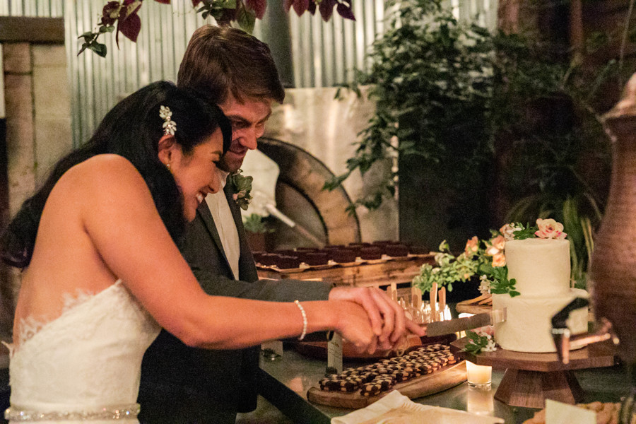 The bride and groom slice their cake at their San Francisco ethical wedding