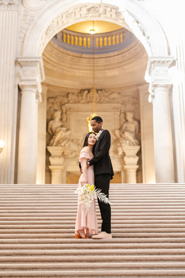 The Newleyweds embrace on the steps of their wedding at San Francisco City Hall.