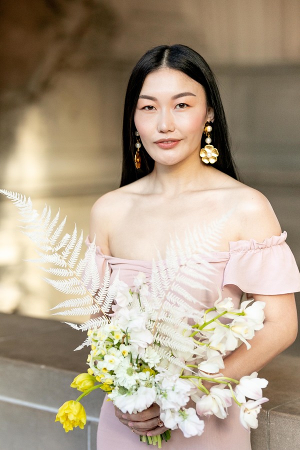 A portrait of blushing bride, Claire, who wore a blush reformation dress for her civil ceremony and San Francisco City Hall Wedding. The bride also handmade her unique and elegant diy wedding bouquet!