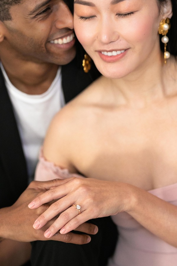 A close up shot of Mickael and Claire posing and holding her engagement ring at their San Francisco City Hall wedding.