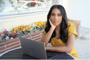 An entrepreneur woman in front of a laptop looking at the camera
