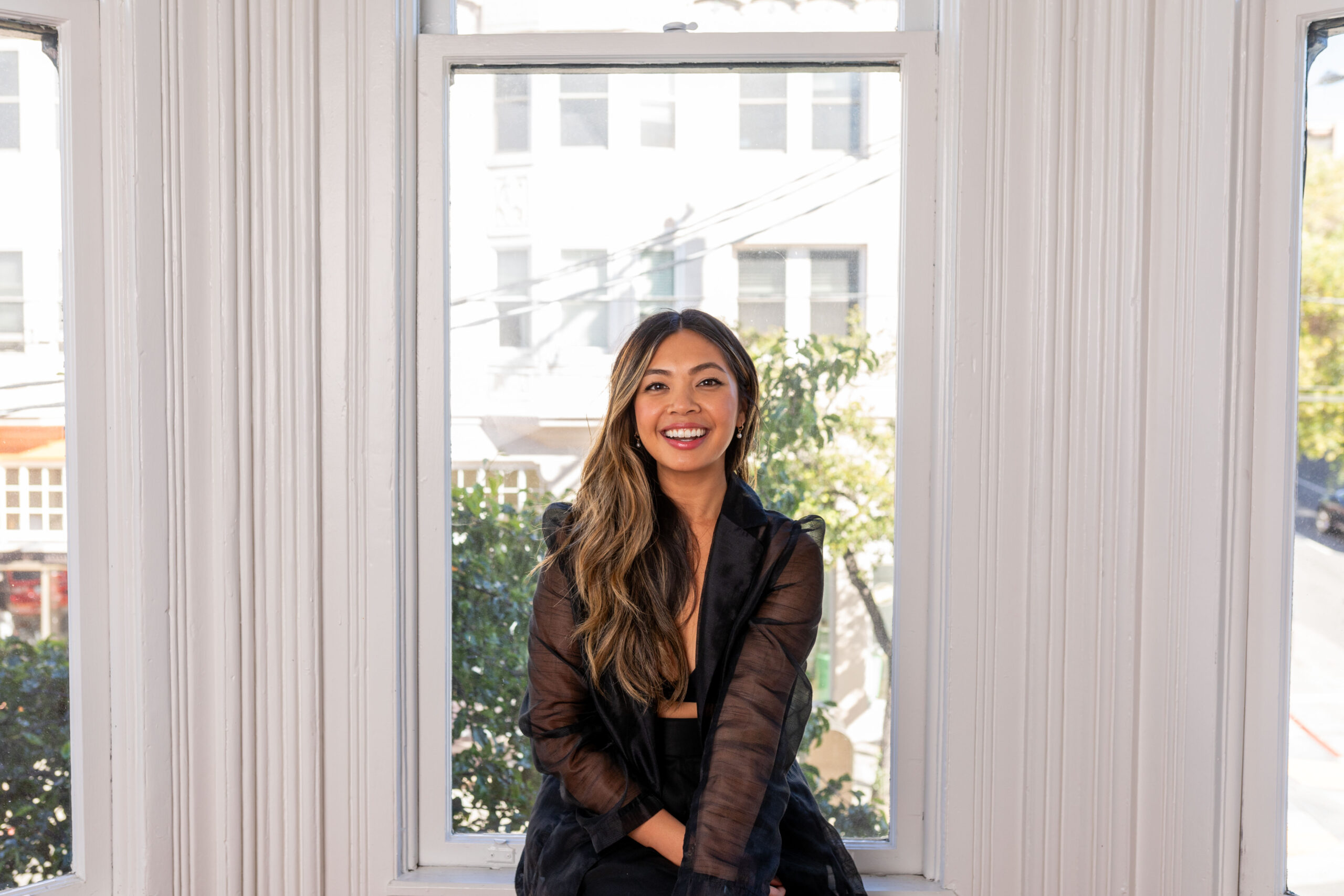 woman sitting on a window ledge inside