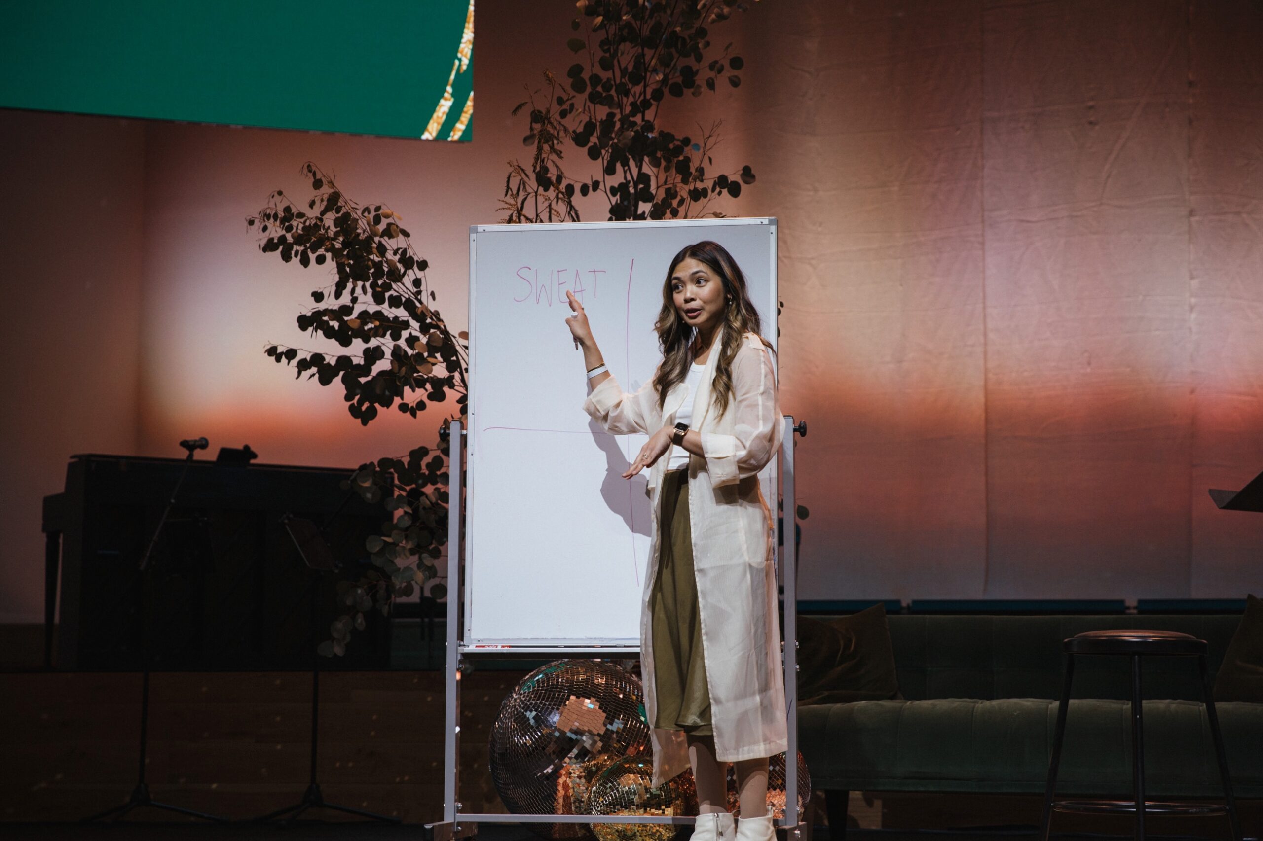 Woman pointing to whiteboard teaching from a stage